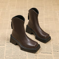 Black women's platform ankle boots with square toe, chunky sole, and rear zip fastening.