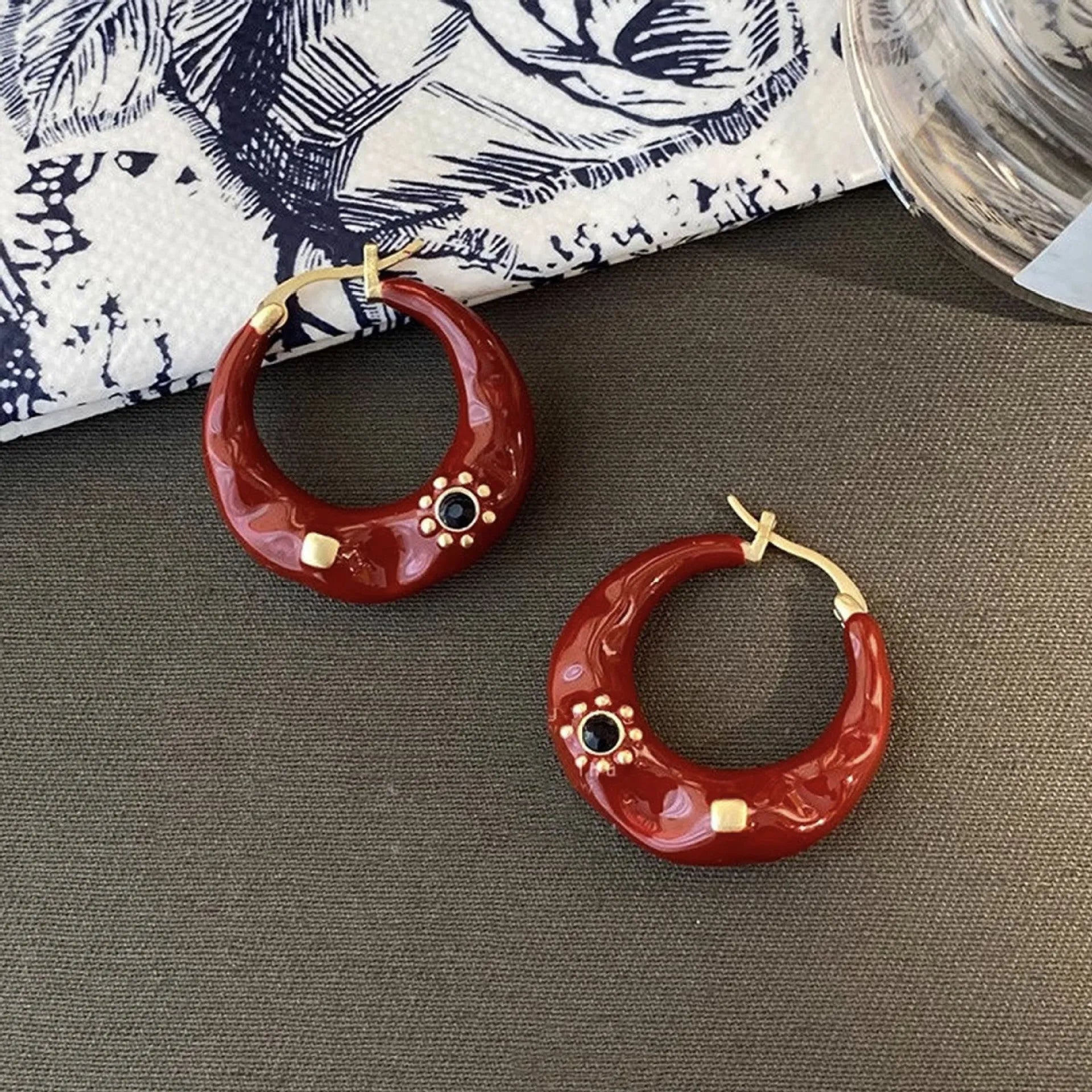 Retro style ear studs with dripping oil finish and rhinestone detailing in black and red colours