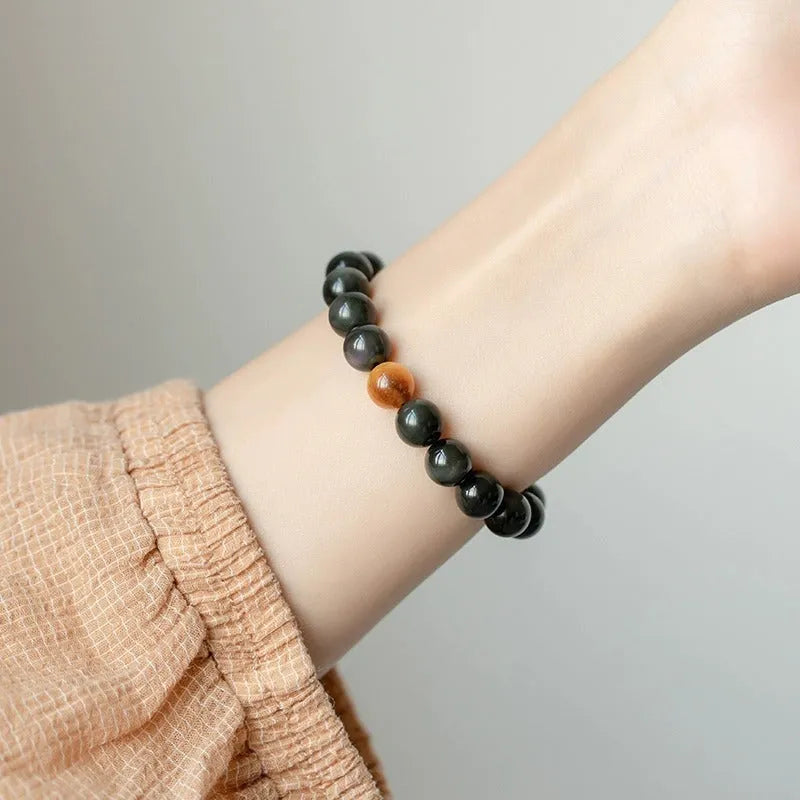 Natural black obsidian bracelet with geometric beads in 10mm size on neutral background