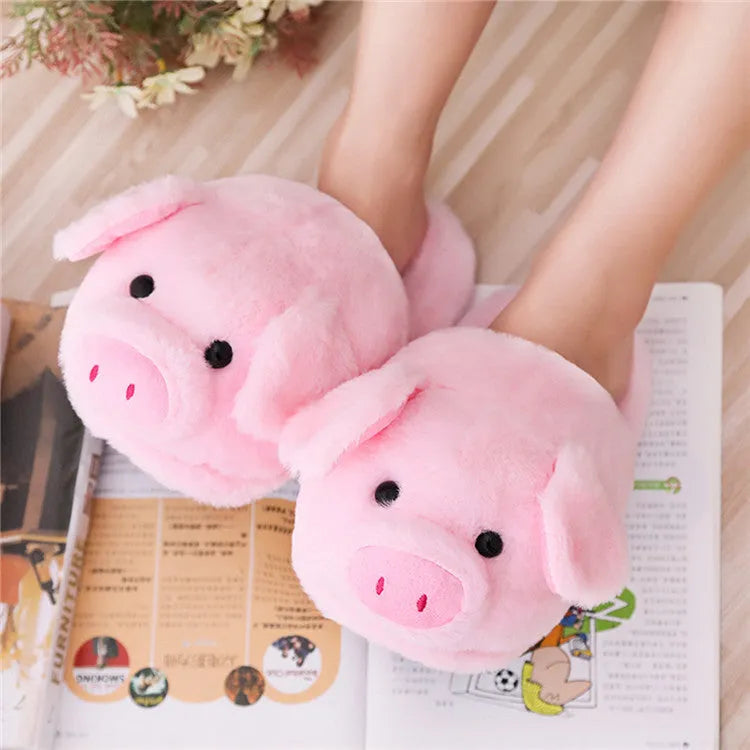 Pair of soft pink pig-shaped plush slippers with a cute animal face design.