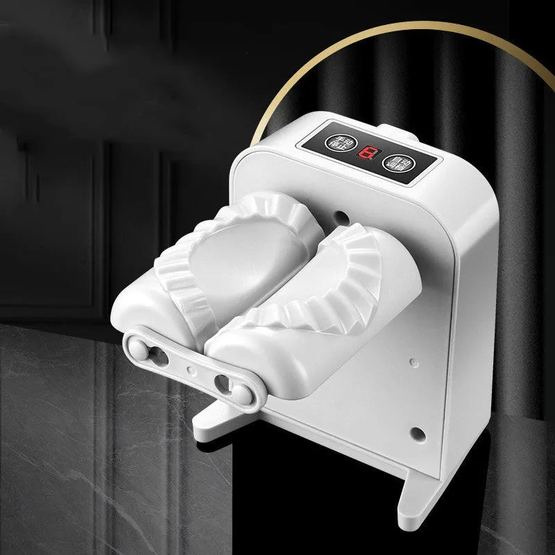 White automatic electric dumpling maker machine on a kitchen counter with USB cable and accessories