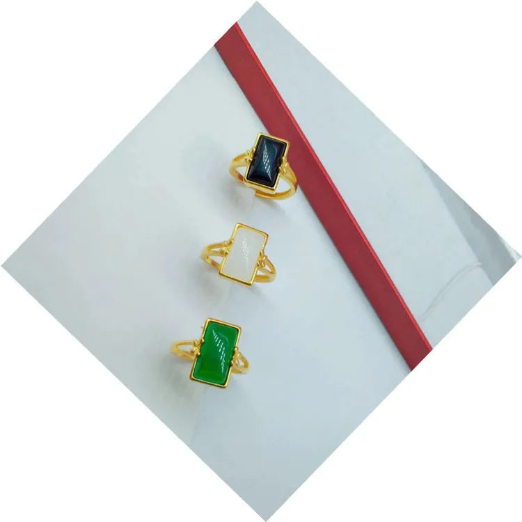 Adjustable brass gold-plated ring with electroplated finish and a coloured gemstone.