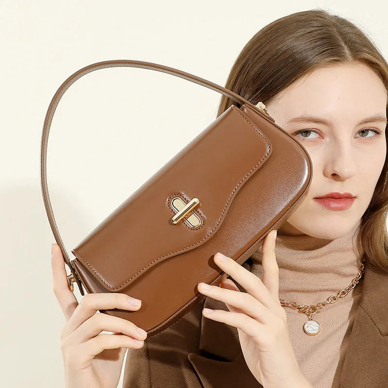 Genuine leather baguette handbag in black with clamshell opening and lock detail