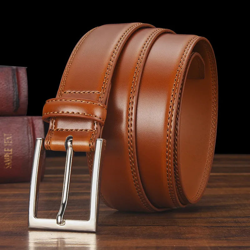 Men's black genuine leather belt with a silver alloy pin buckle on a plain background.