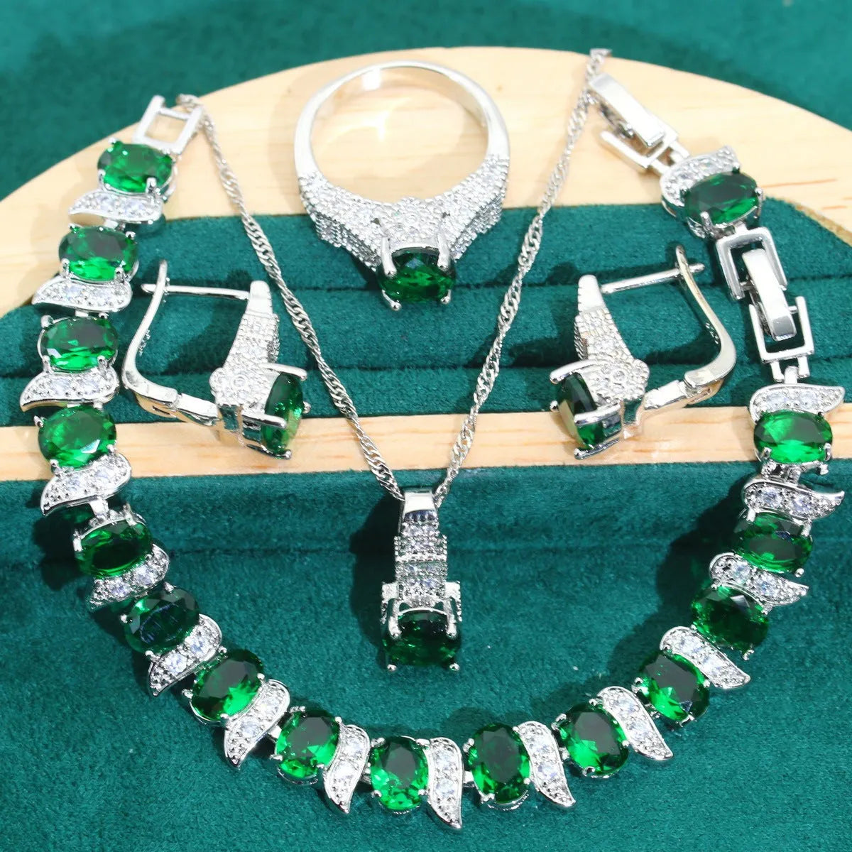 Bridal jewellery four-piece set with zircon pendants showing necklace, bracelet, earrings and ring with water wave chain design