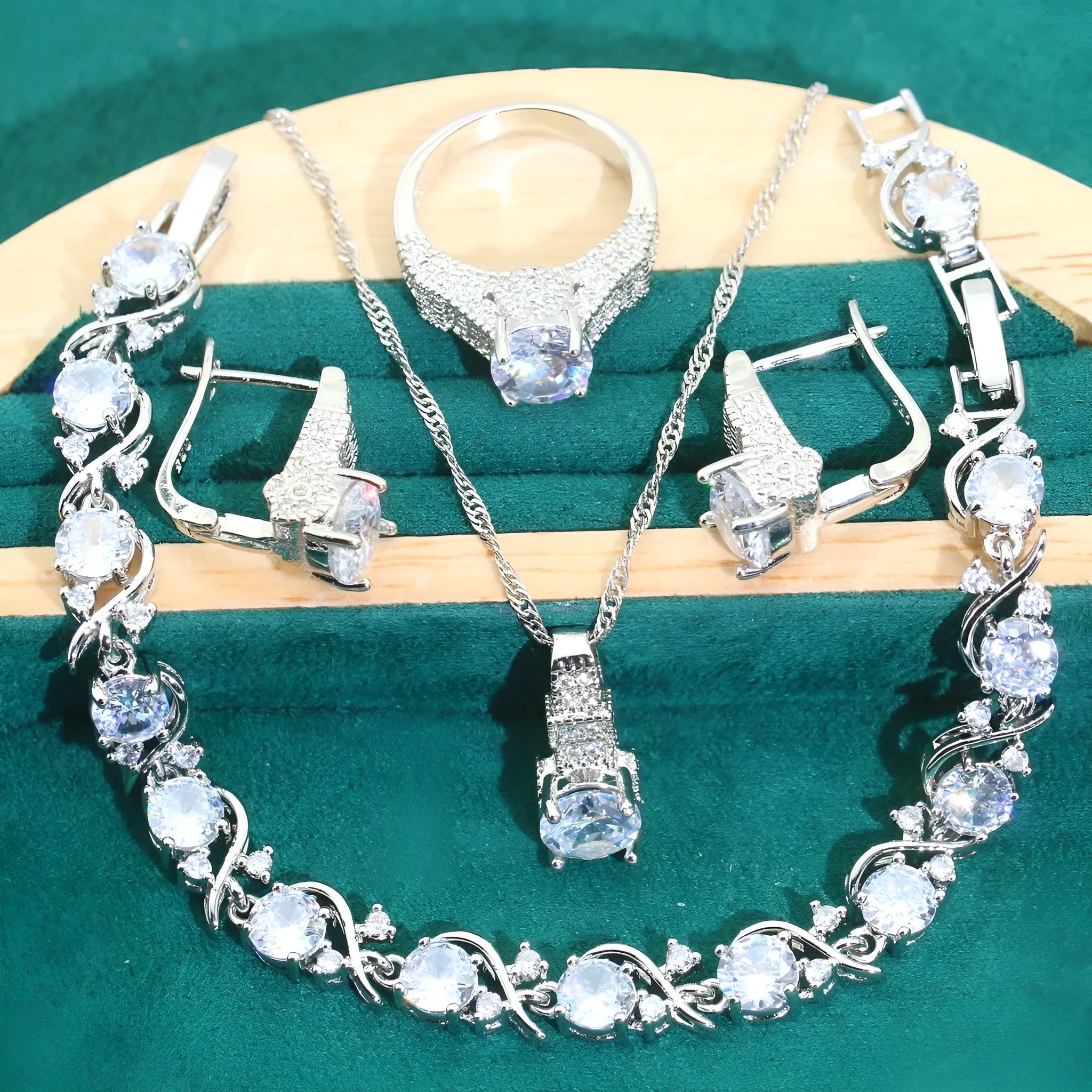 Bridal jewellery four-piece set with zircon pendants showing necklace, bracelet, earrings and ring with water wave chain design