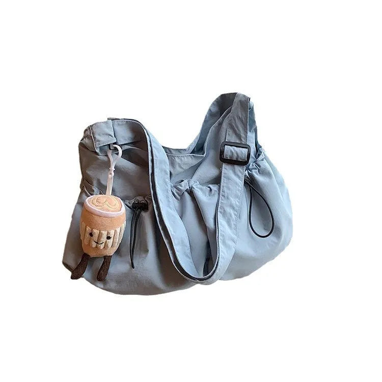 Ultra-light pleated crossbody student cloth bag in soft polyester, showing split pocket and internal phone storage.