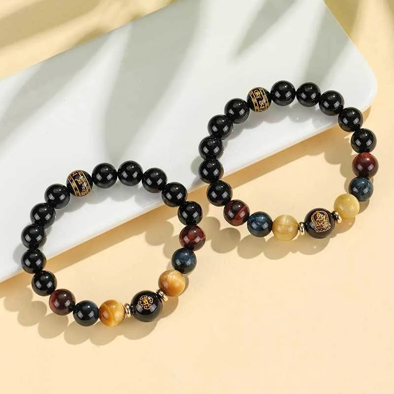 Black agate beaded bracelet with tiger eye stones in ethnic style on plain background