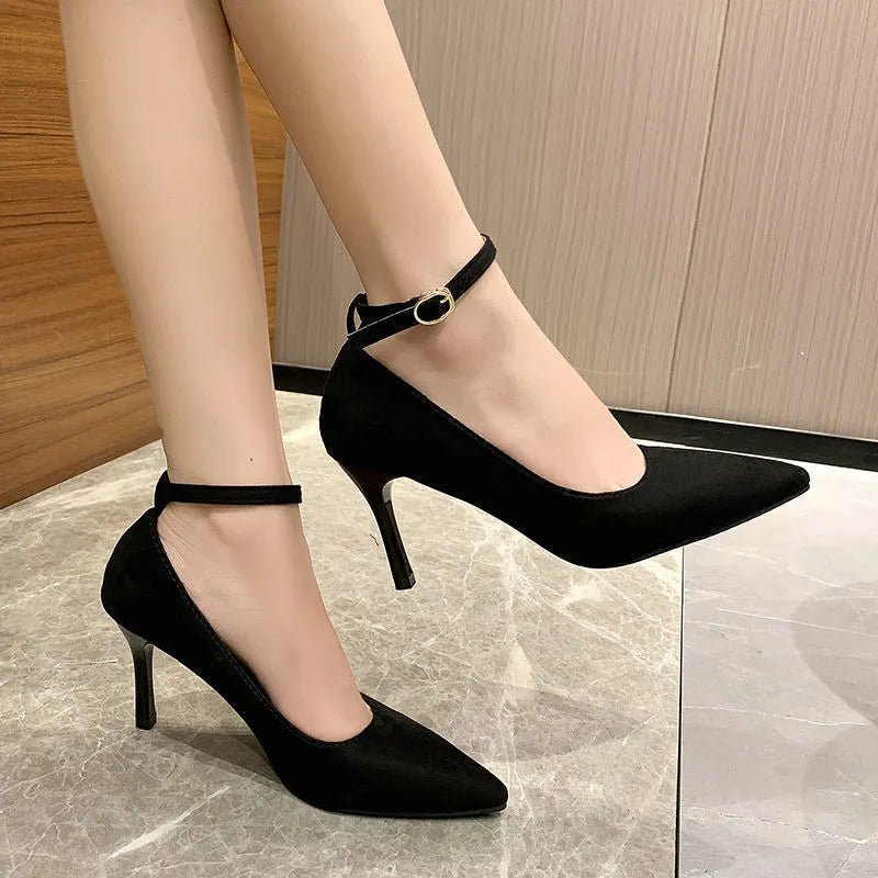 Women's black stiletto heel pump shoes with a buckle detail on the upper.