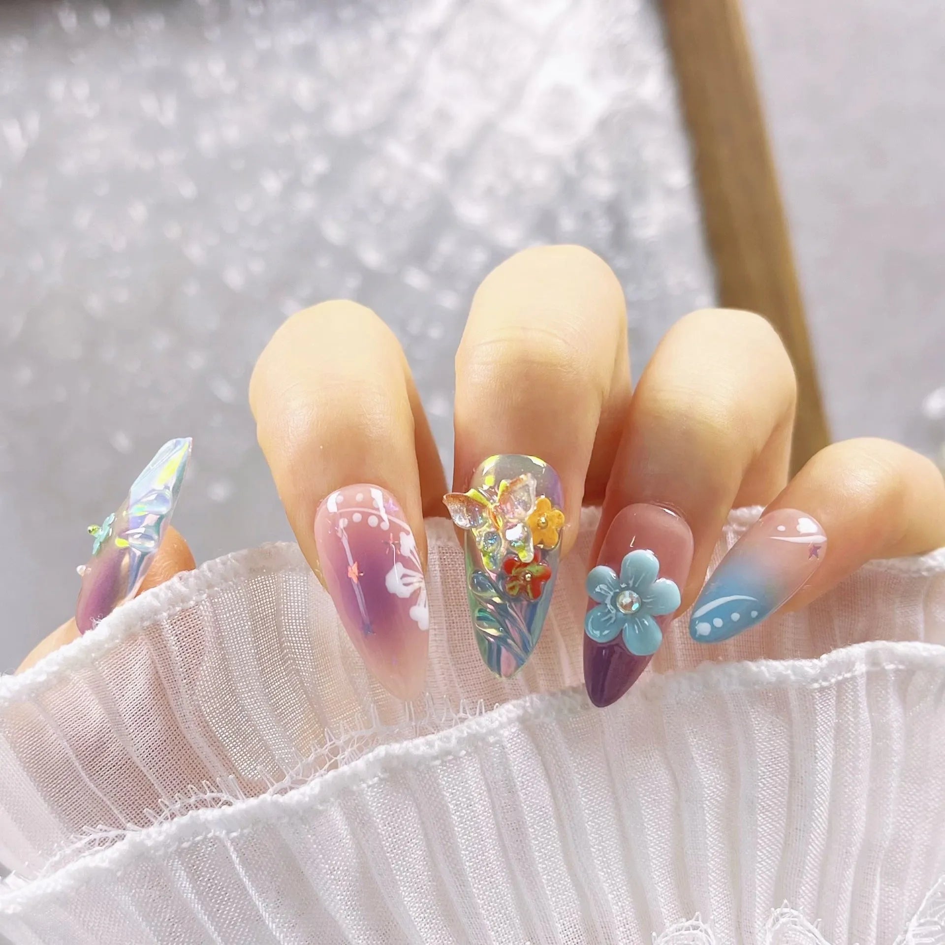 Handmade colourful nail sculptures with floral patterns and embossed butterfly designs