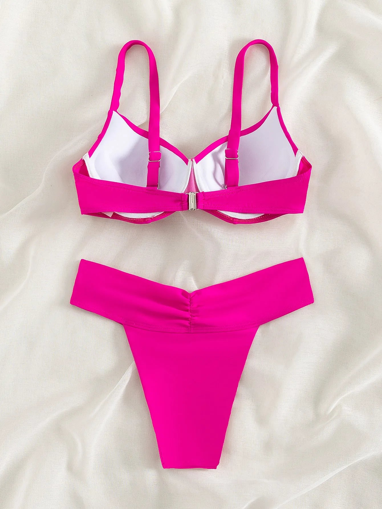 Solid colour bikini swimsuit in fluorescent pink on a mannequin, showing briefs style and sleeveless design.