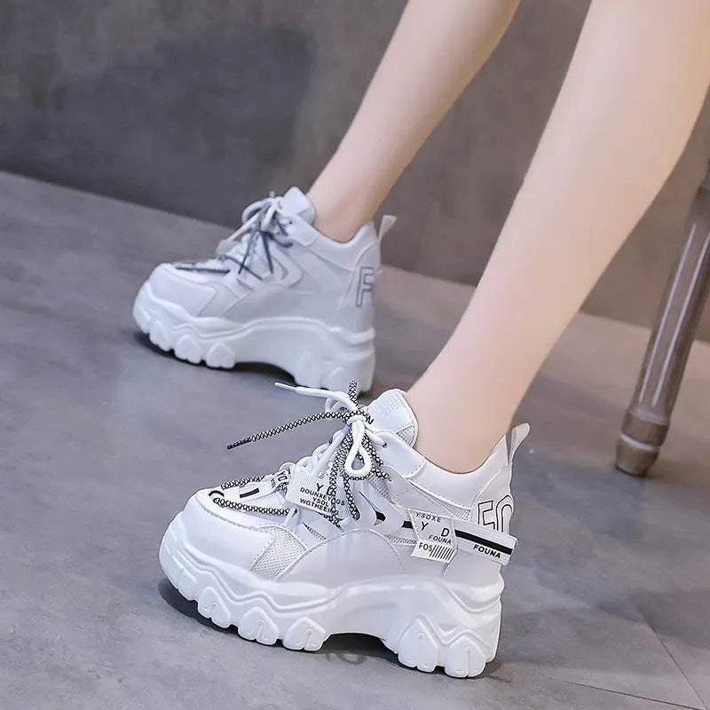 Women's white mesh platform trainers with cross strap and rubber sole showing side profile