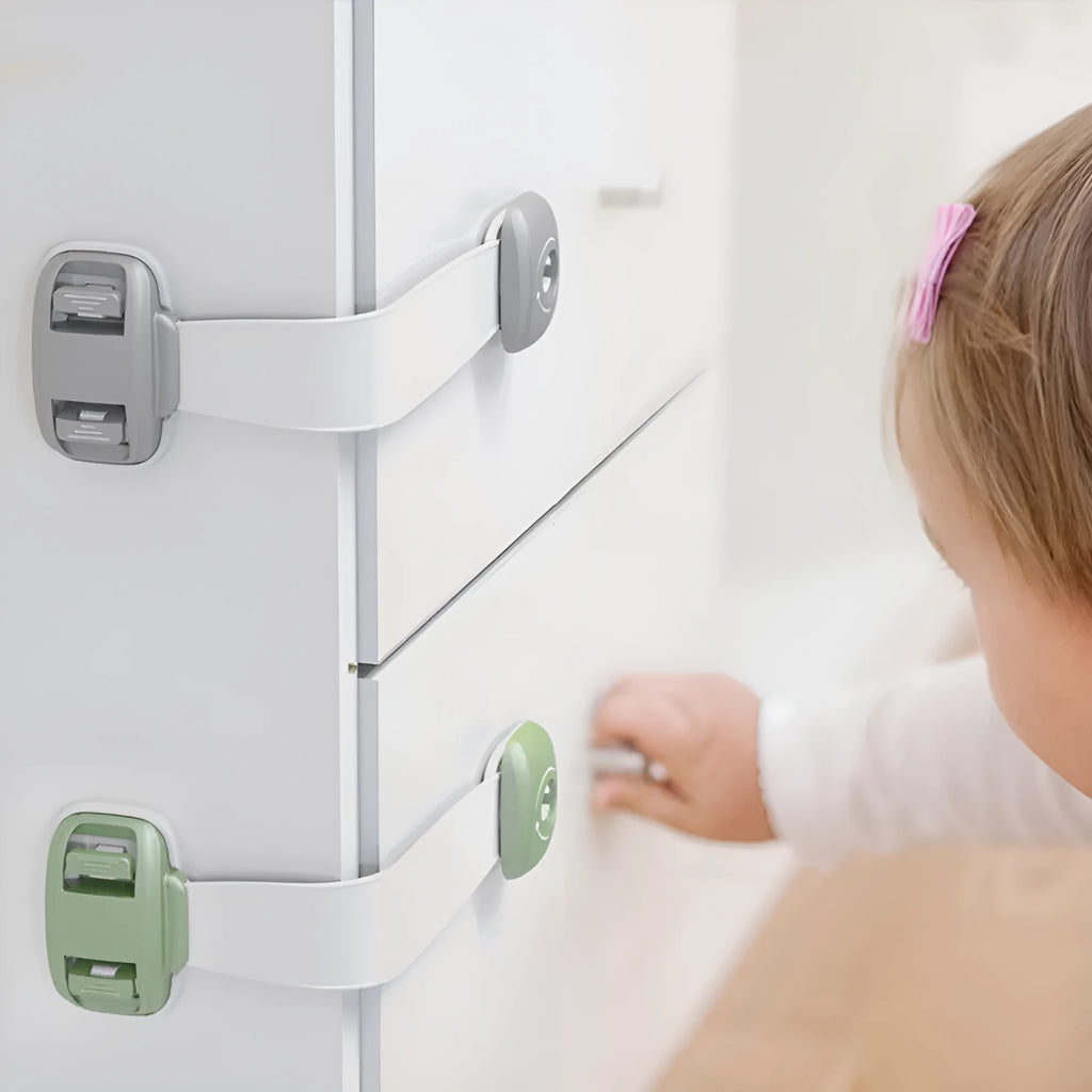 Gray child safety lock with adjustable strap attached to a cabinet handle, 53 x 112 x 16mm