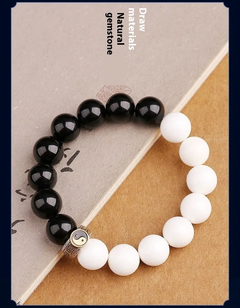 Black and white obsidian geometry-shaped bead bracelet on neutral background