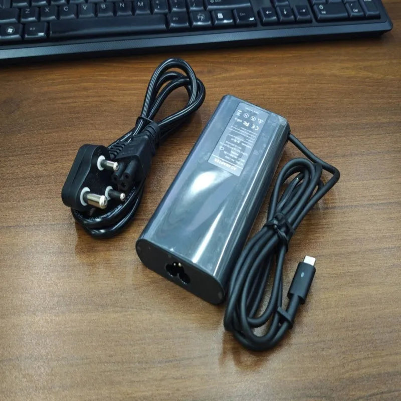 Black 65W USB-C laptop power adapter with multiple international plug attachments