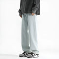 Men's light blue washed straight leg jeans with button waist closure on a solid background