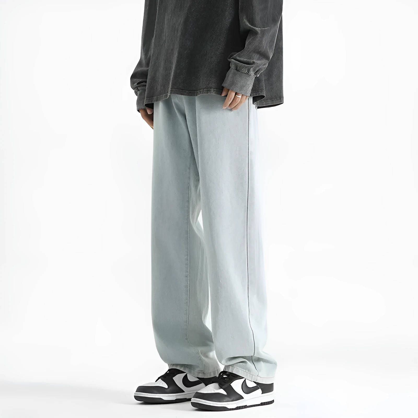 Men's light blue washed straight leg jeans with button waist closure on a solid background