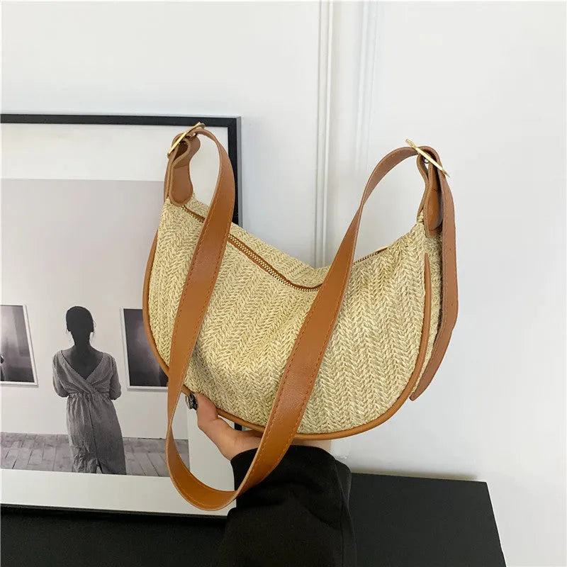 Women's knitted straw woven crossbody bag showing woven texture and internal phone and document pockets