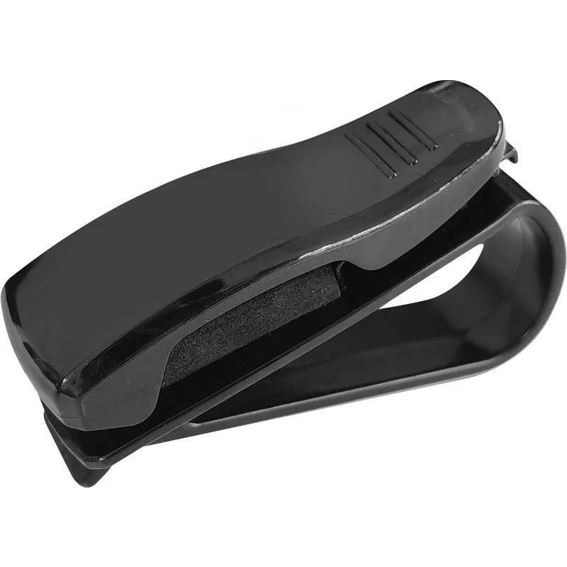 Black plastic clip for car sunshade holding a ticket and glasses