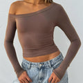 Women's slim fit knitted cardigan in black with long sleeves and decorative cross shoulder straps.