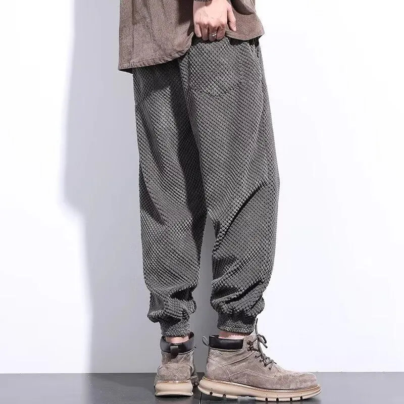 Grey men's casual sweatpants with ankle tie fastening and straight leg on a neutral background.