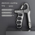 Orange electronic counter spring grip trainer held in a hand.