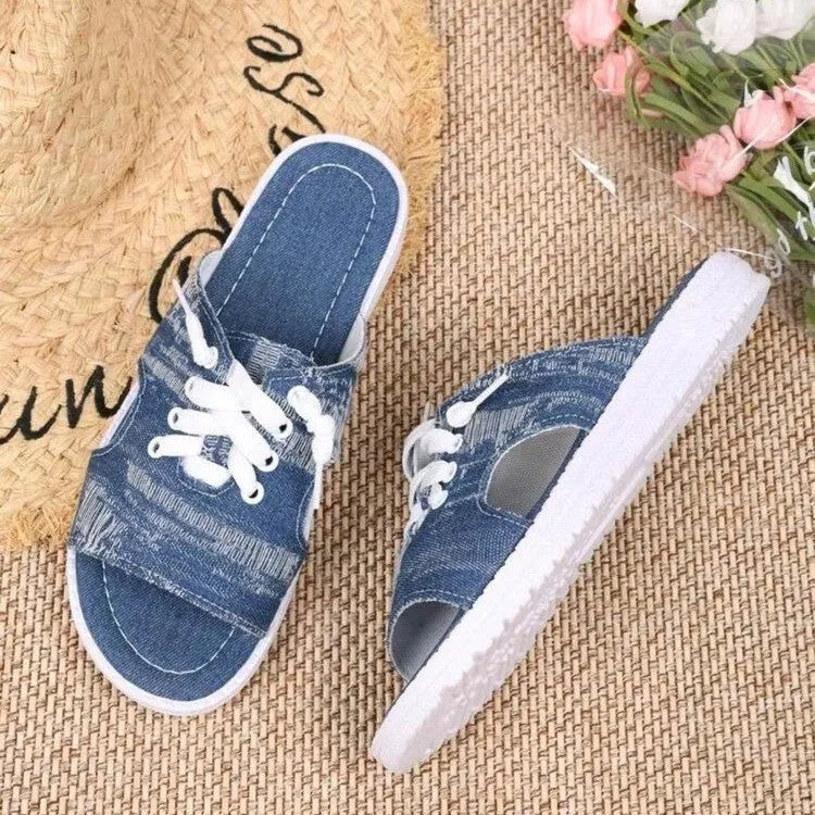 Blue women's Roman style flat canvas slippers with a cloth upper and rubber sole.