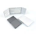 Mini tri-fold aluminium Bluetooth keyboard shown folded to 30.2cm length beside smartphone