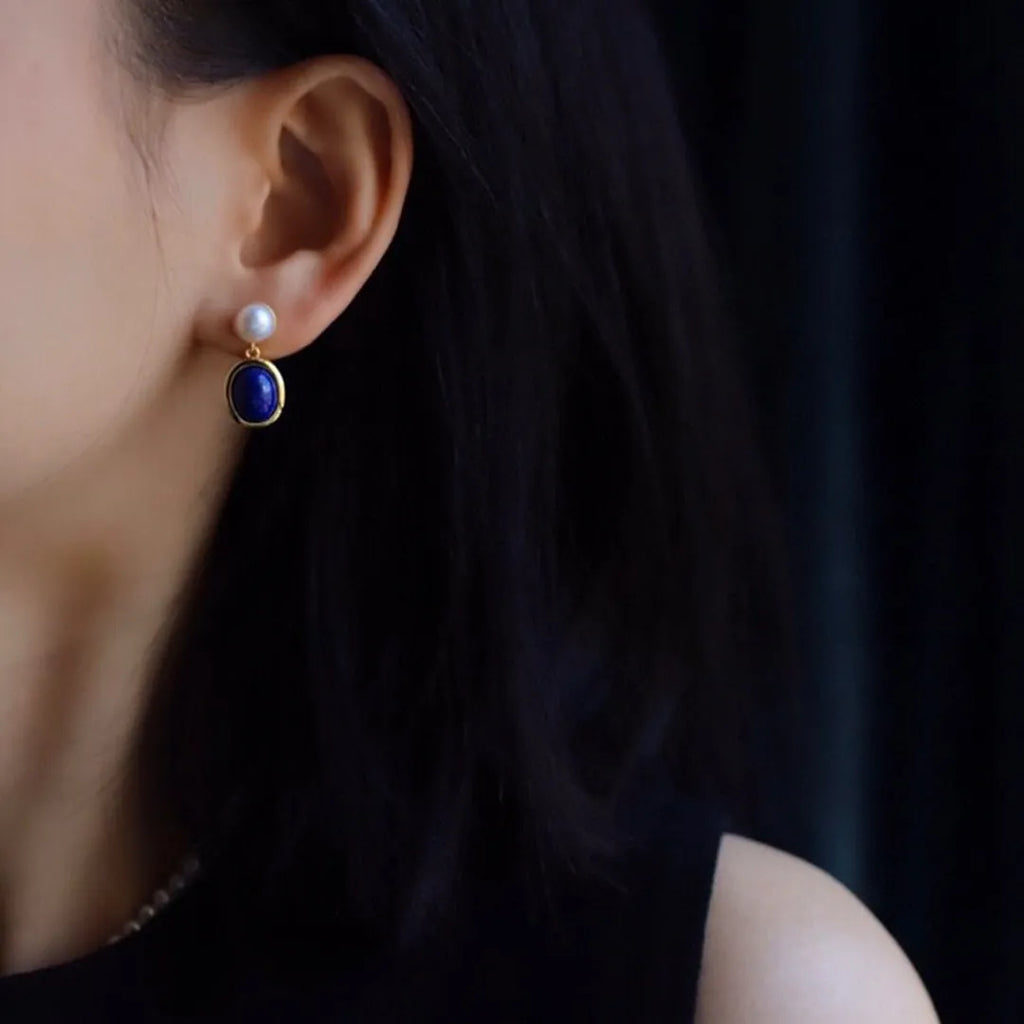 A pair of simple 925 silver earrings with blue lapis lazuli pearls and auspicious patterns.