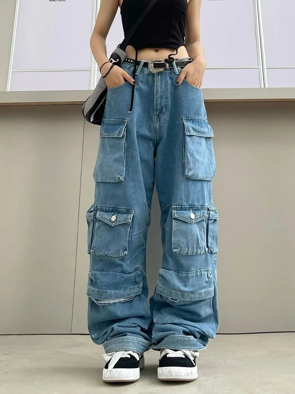 Women's blue tie-dyed wide-leg high-waist jeans with multiple pockets on a street hipster style denim overall.