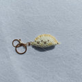 Handmade crochet dumpling pendant with keychain in plush material with two hand-stitched eyes