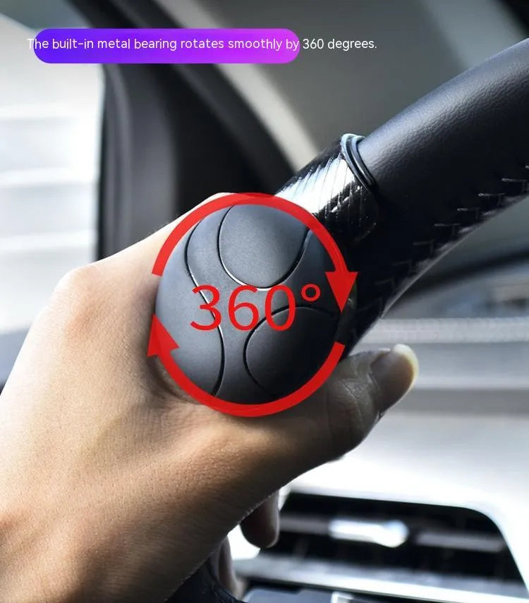 Black silicone steering wheel assist ball with metal bearing on a car steering wheel.