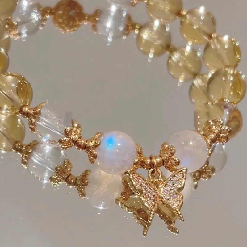 Moonstone white crystal beaded bracelet with citrine butterfly charm on display