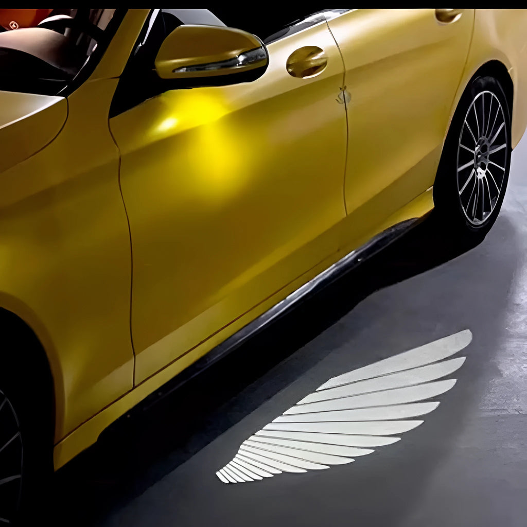 Car rearview mirror courtesy lamp projecting white angel wings light onto ground near vehicle door