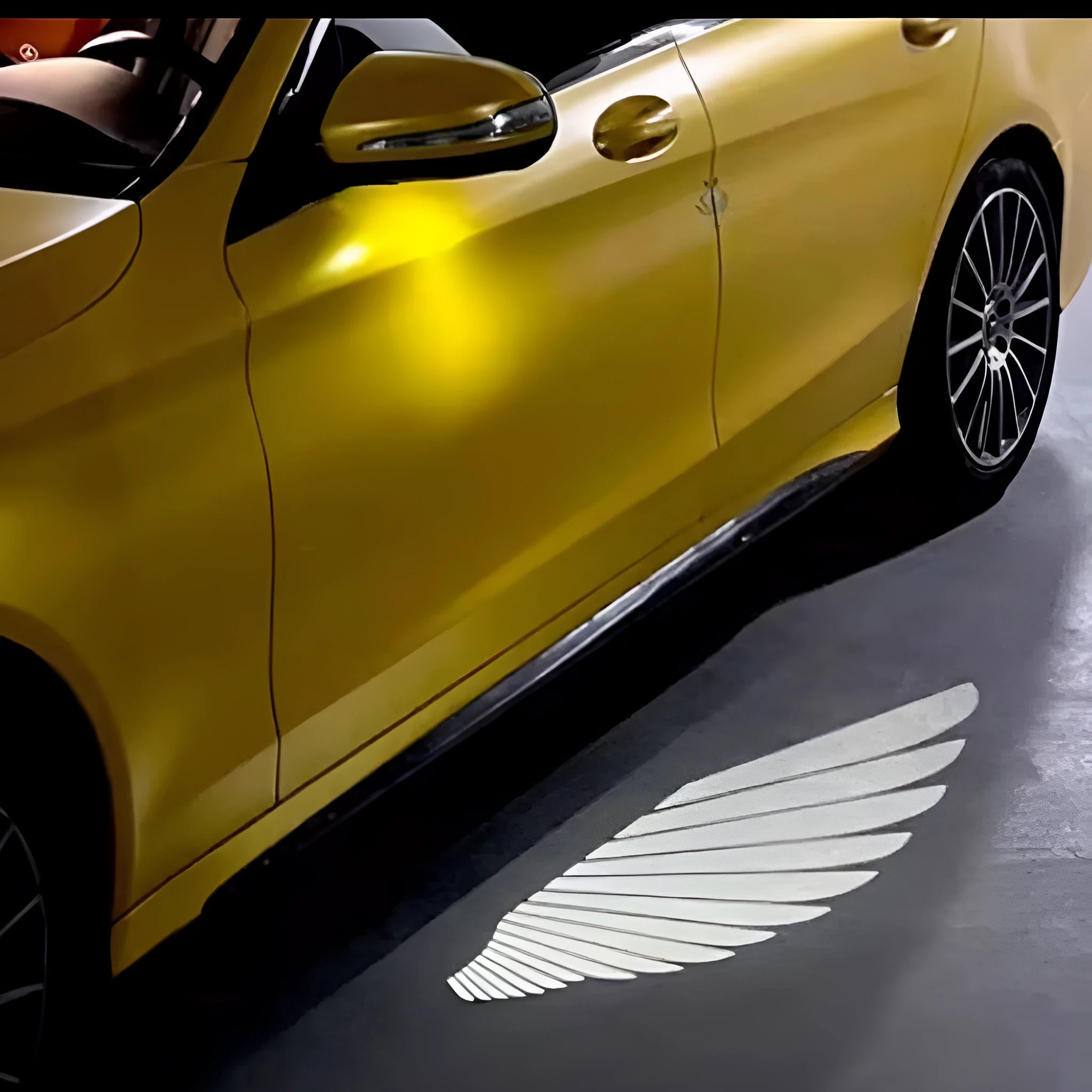 Car rearview mirror courtesy lamp projecting white angel wings light onto ground near vehicle door