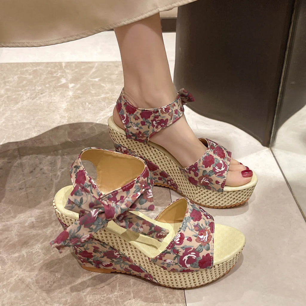 Women's wedge peep toe sandals with ankle-strap buckle, cloth upper, and rubber sole in a floral pattern.
