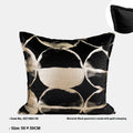 Black and gold abstract patterned decorative flannel cushion on a grey sofa.
