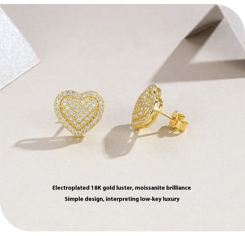 Gold-coloured heart-shaped moissanite stud earrings made from S925 silver on a plain background.