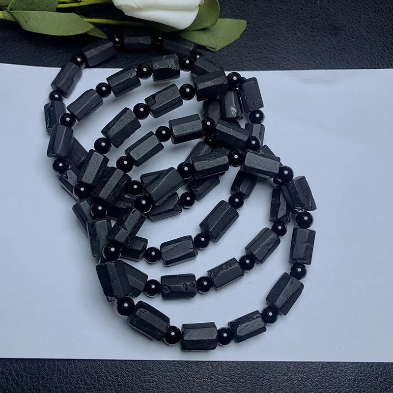 Natural black tourmaline rough stone bracelet unisex 10mm bead size on plain background