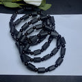 Natural black tourmaline rough stone bracelet unisex 10mm bead size on plain background