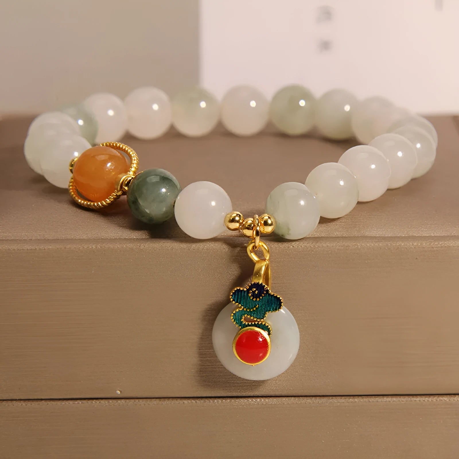 Ice jade colour women's bracelet with xiangyun buckle and pearl details.