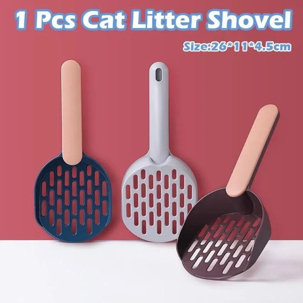 Plastic cat litter shovel in blue, green, and pink colours on a clean surface
