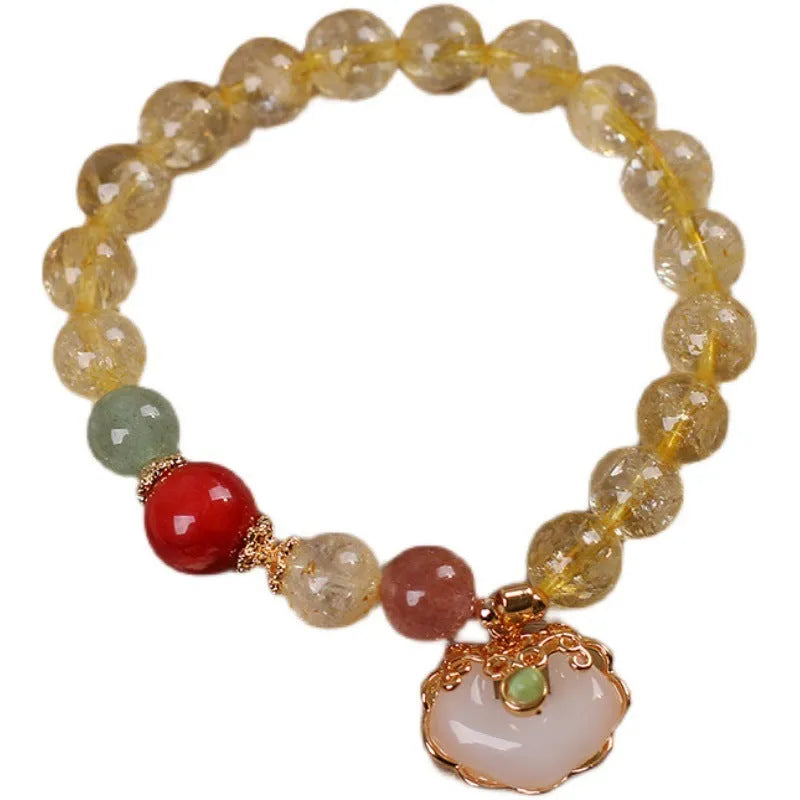 Close-up of a women's adjustable bracelet with a yellow citrine jade ruyi pendant on an alloy chain.