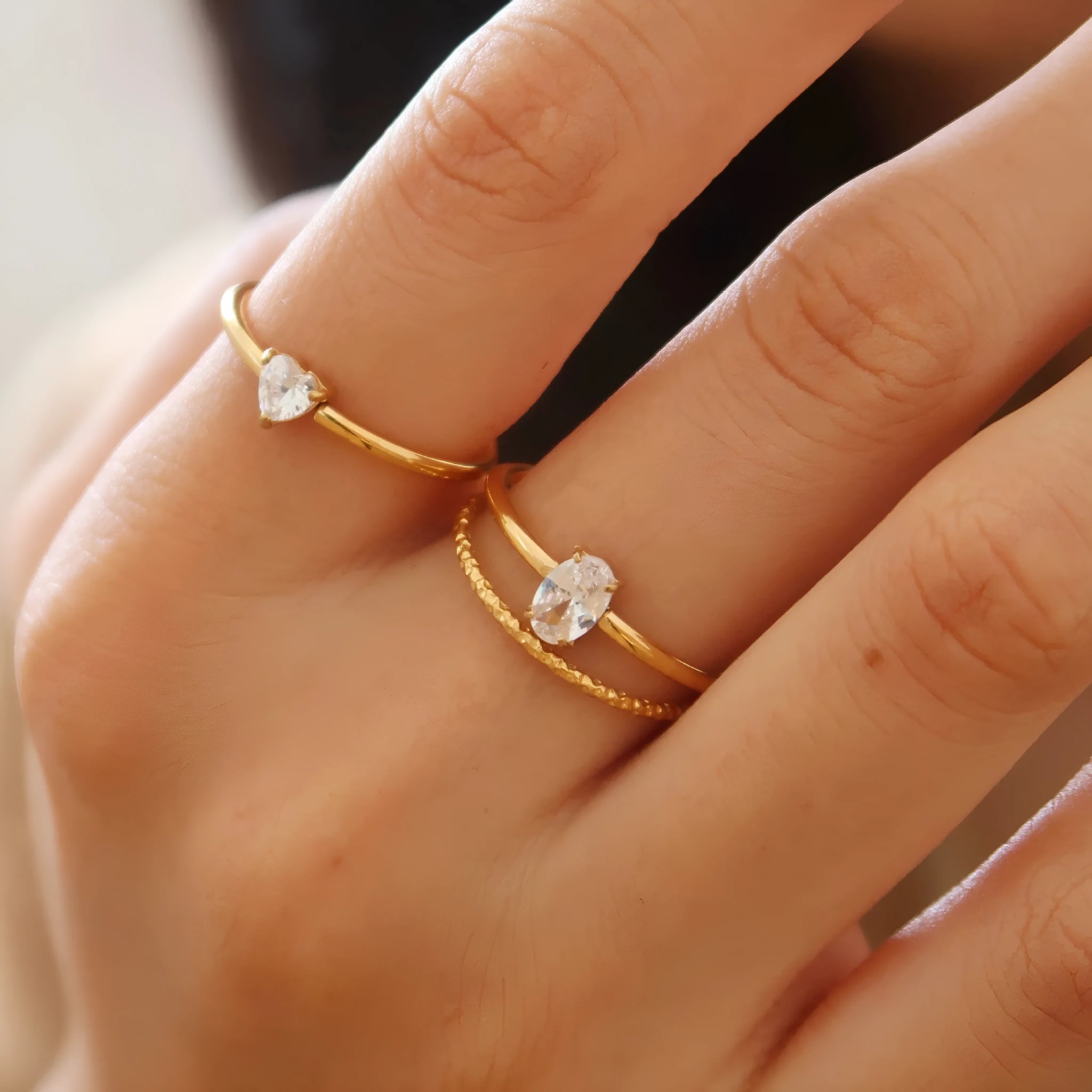 Golden stainless steel ring with heart shape on oval band, shown in size options 5 through 8
