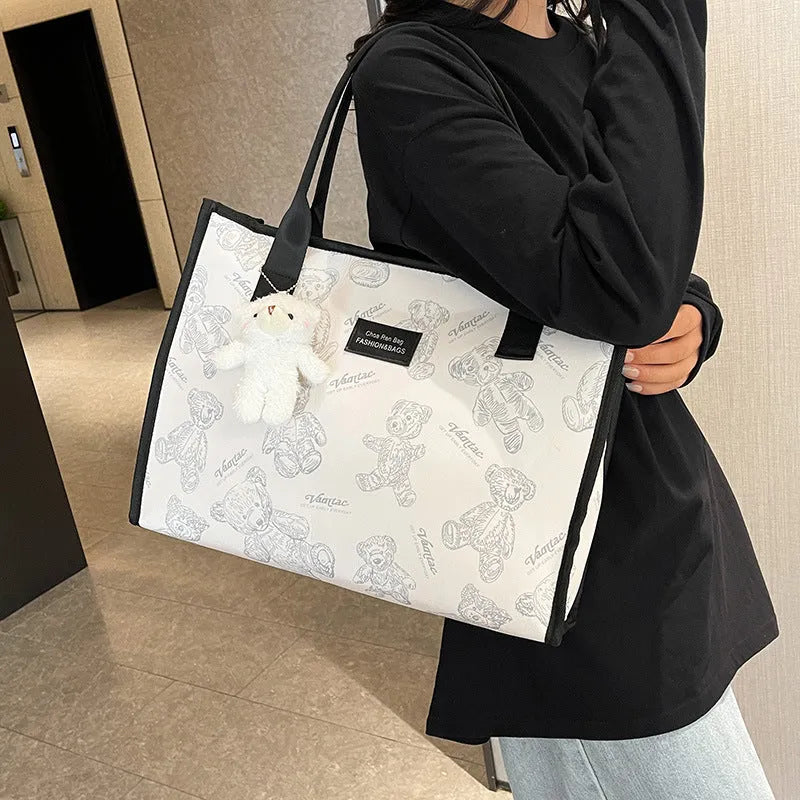 Women's printed canvas tote bag with large capacity, shown in black and white colour options with optional pendant