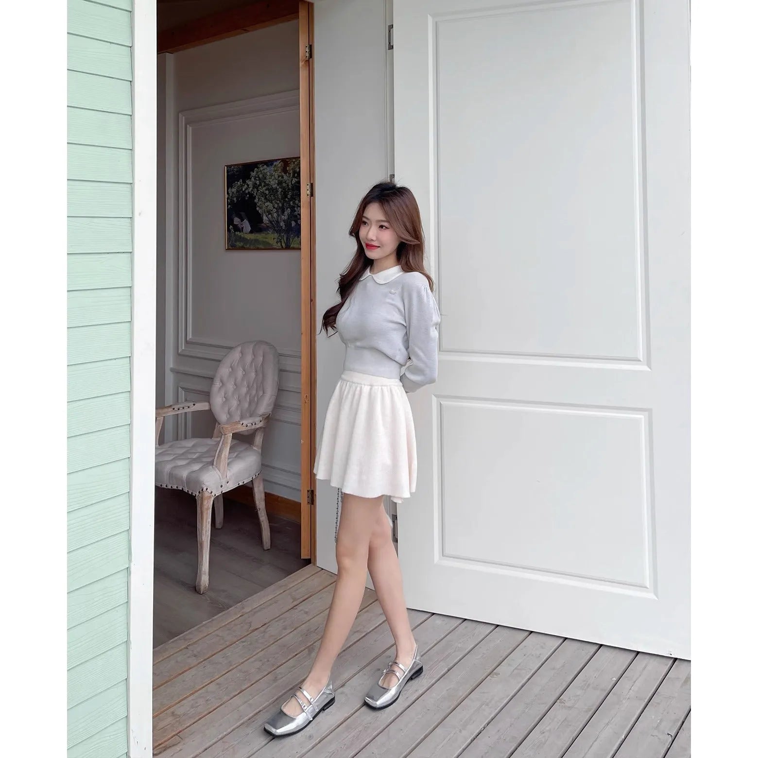 Women's silver leather Mary Jane pumps with a cross buckle strap and flat sole.