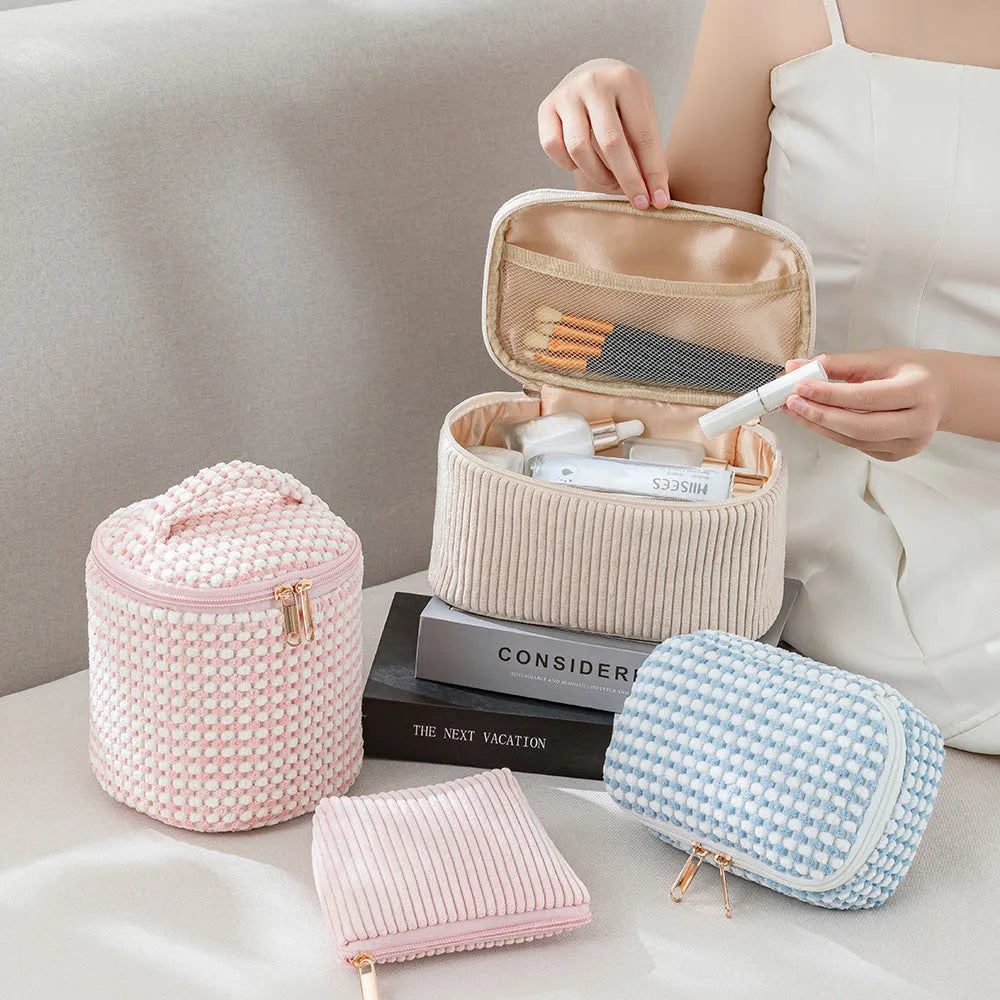 Four cube-shaped flannelette makeup bags in coordinated colours for travel organisation