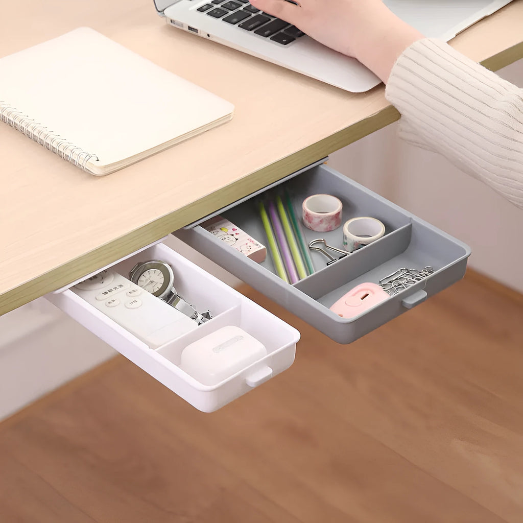 White plastic under-desk storage box with a lid open, showing an internal grid pattern.