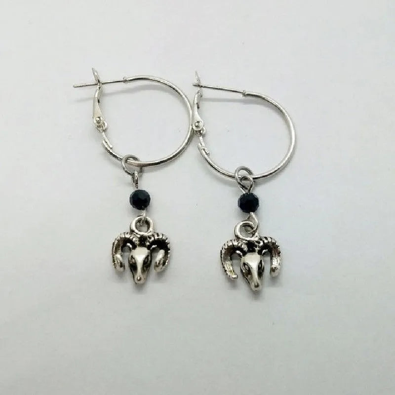 A pair of silver round ring earrings with a Tibetan antelope design.