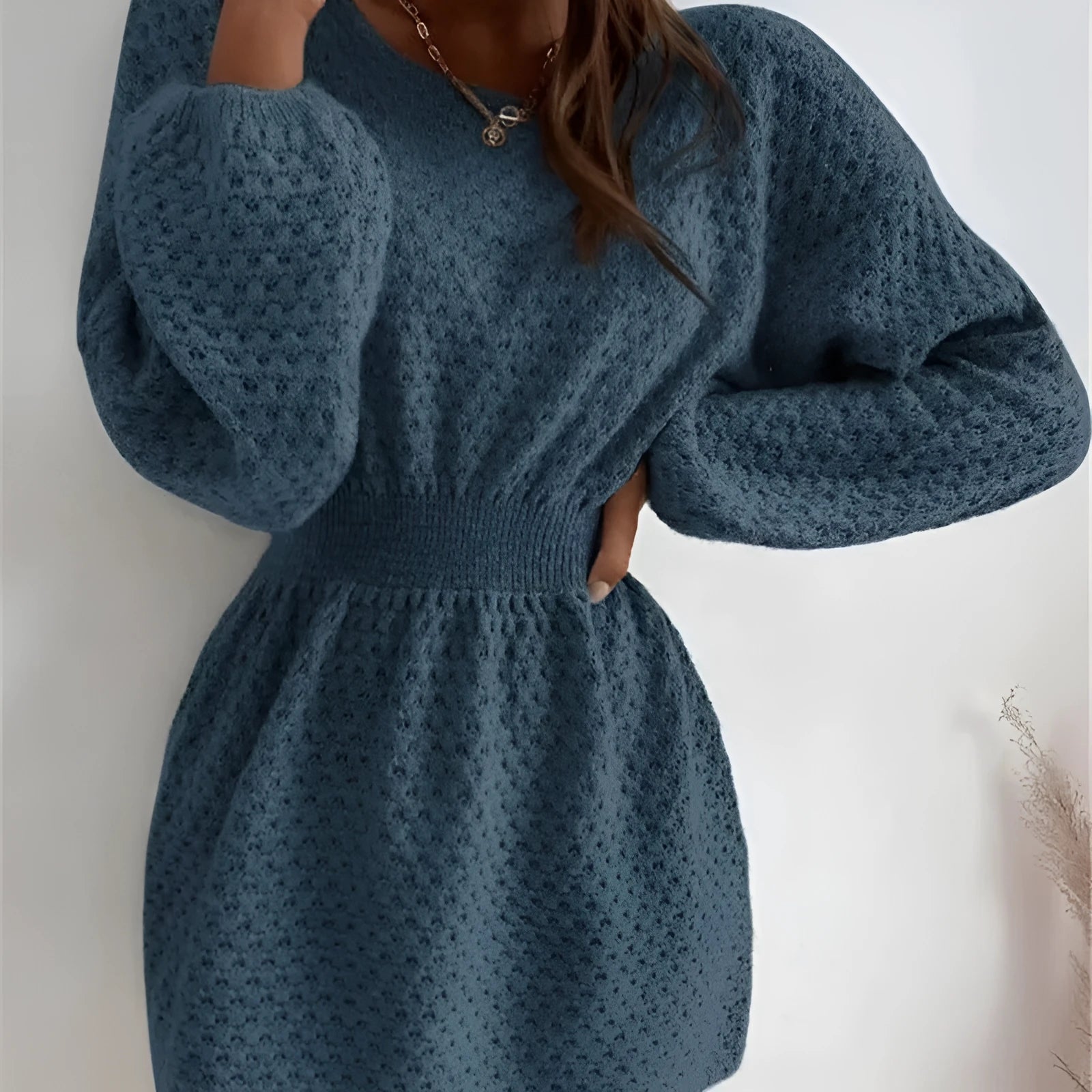 Blue women's knitted dress with hand-crocheted flowers, round neck, fitted waist, and long sleeves